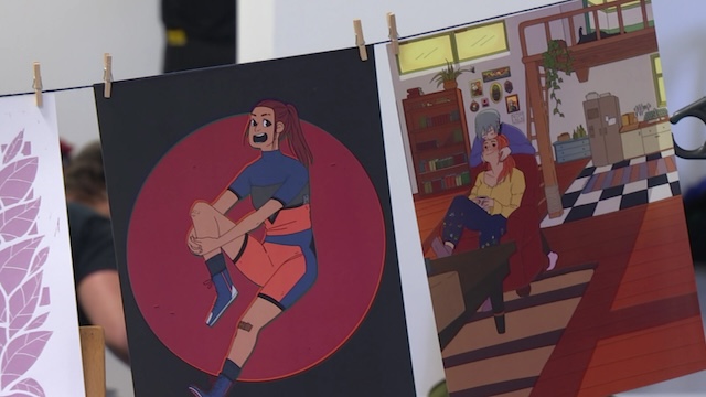 Selbstgemalte Kunst hängt an einer Wäscheleine.