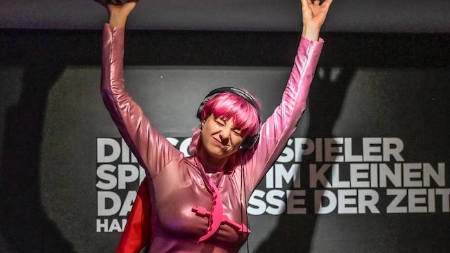 Eine junge Frau in Pink auf der Bühne.